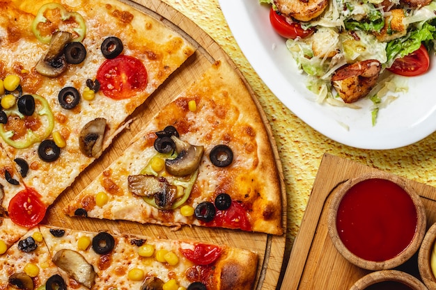 Top view mushroom pizza with black olive corn bell pepper tomato and cheese on a board