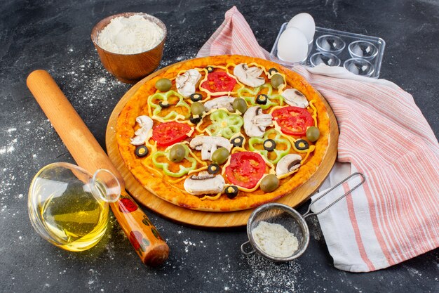 Вид сверху грибная пицца с красными помидорами, маслинами, грибы, нарезанные внутри маслом на сером фоне, тесто для пиццы итальянское