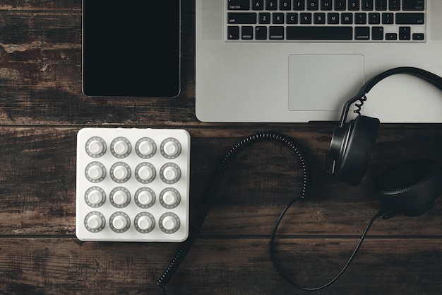 음악 프로덕션 세트 미디 믹서 컨트롤, 태블릿, 노트북 및 가죽 이어 패드가있는 블랙 DJ 헤드폰의 상위 뷰
