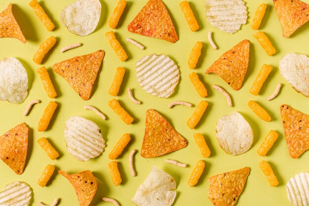 Top view of nacho chips with potato chips and cheesy puffs