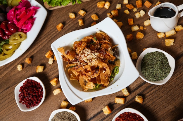 Top view nachos with cheese with spices sauce and croutons on the table