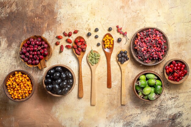 Top view of natural and fresh various fruits in small brown wooden pots and spoons