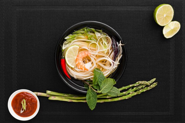 Top view of noodles in bowl with asparagus