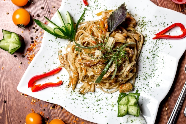 Top view noodles with vegetables and with corn cucumber and bell pepper