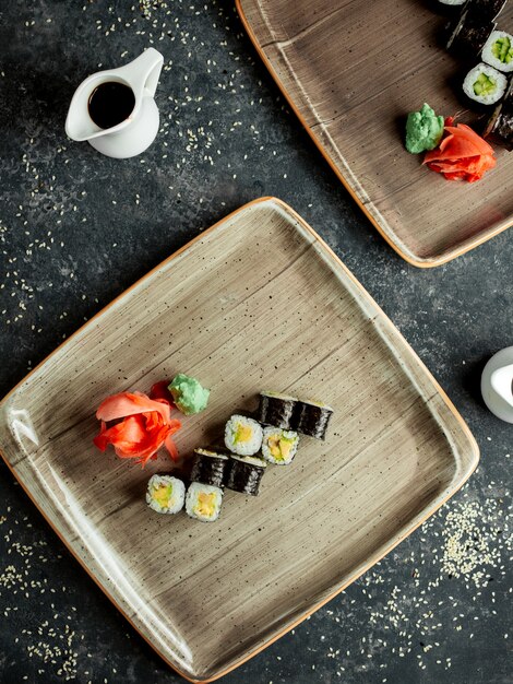 Top view of nori sushi with avocado served with ginger and wasabi