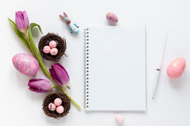 Free photo top view notebook beside flowers and easter eggs