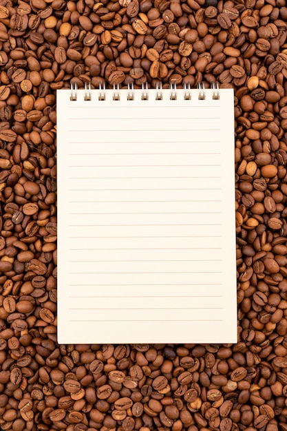 Top view notebook on coffee beans surface