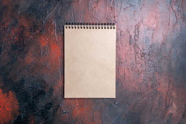 Free photo top view a notebook on dark red background with free place