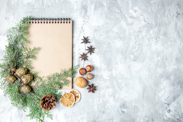 Top view notebook dried lemon slices anises pine tree branches on grey surface