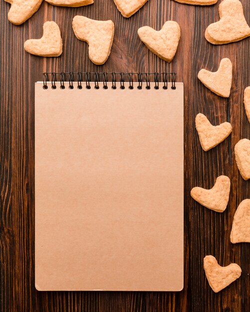 Вид сверху блокнот и печенье в форме сердца Валентина