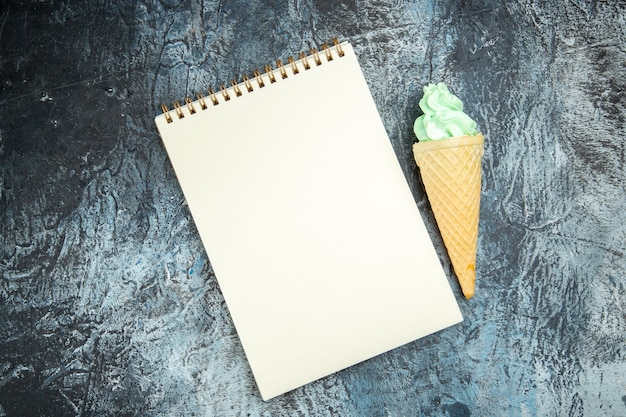 Foto gratuita vista dall'alto un taccuino e un gelato su sfondo scuro