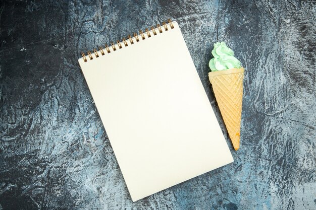 暗い背景にノートブックとアイスクリームの上面図