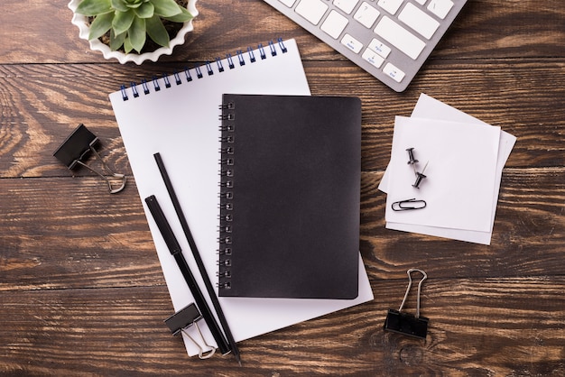 Top view of notebook and keyboard on wooden desk with succulent