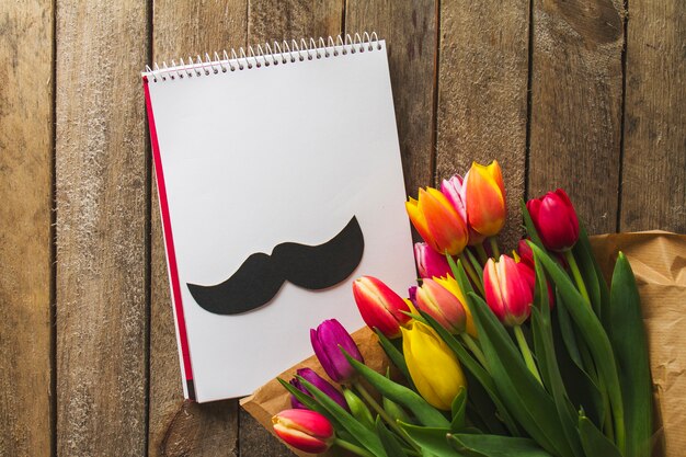 Top view of notebook, moustache and flowers for father's day