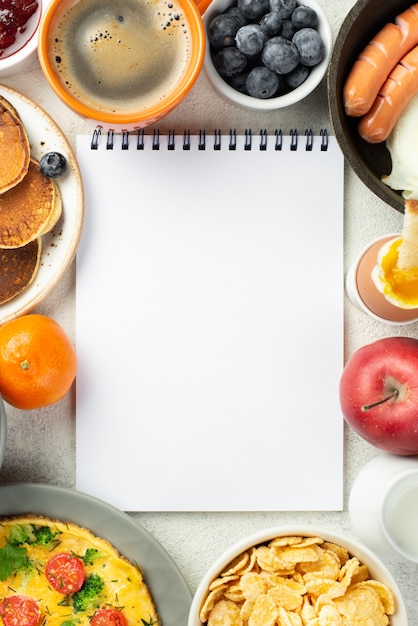 Top view of notebook surrounded by breakfast food