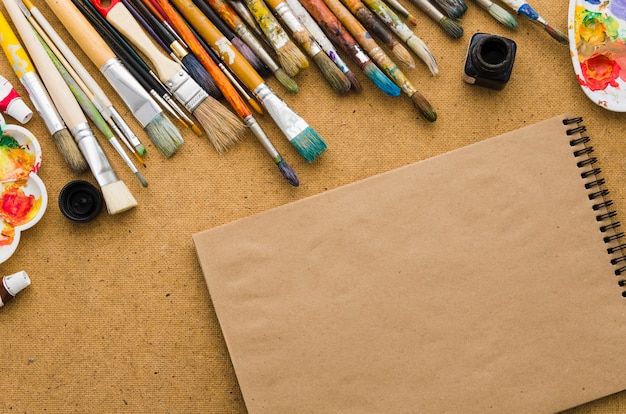 Top view notebook surrounded by painting elements