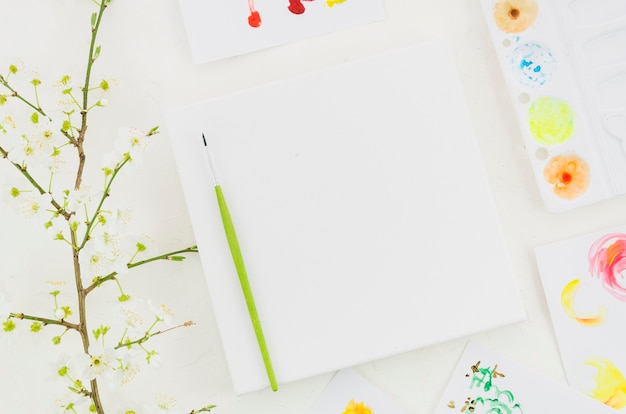 Top view notebook surrounded by painting elements