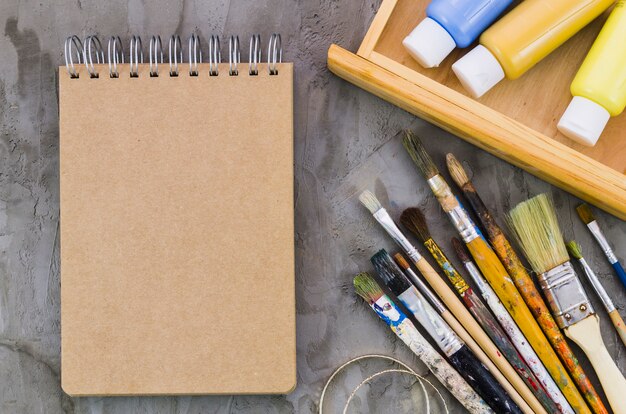 Top view notebook surrounded by painting elements