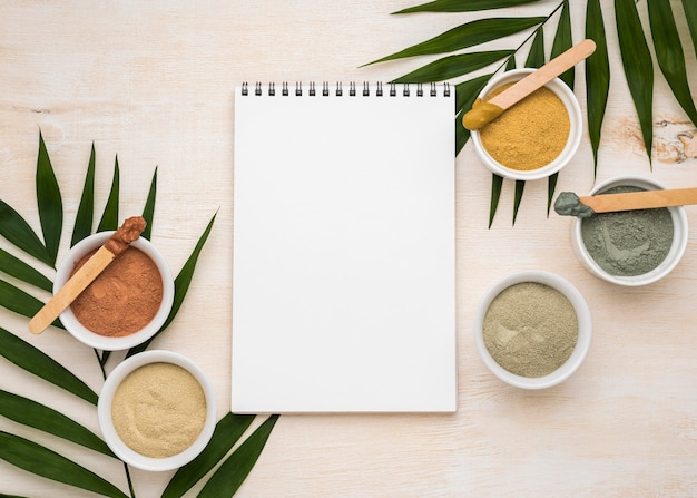 Free photo top view of notebook with assortment of bowls with powder