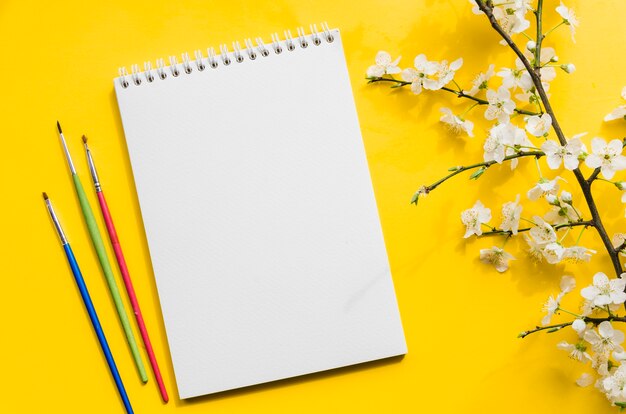 Top view notebook with branch of flowers