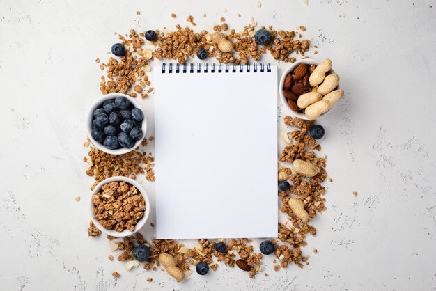 Top view of notebook with breakfast cereal and blueberries