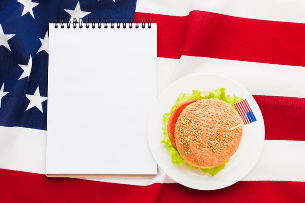 Top view of notebook with burger and american flag