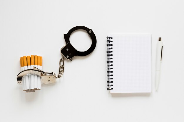 Top view notebook with cigarette and handcuffs