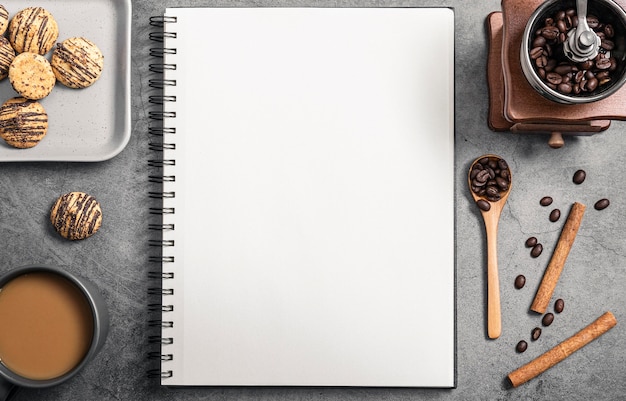 Top view of notebook with coffee grinder and cookies