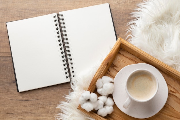 Free photo top view of notebook with cup of coffee and cotton flowers