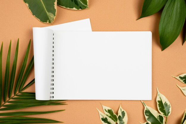 Top view of notebook with different plant leaves