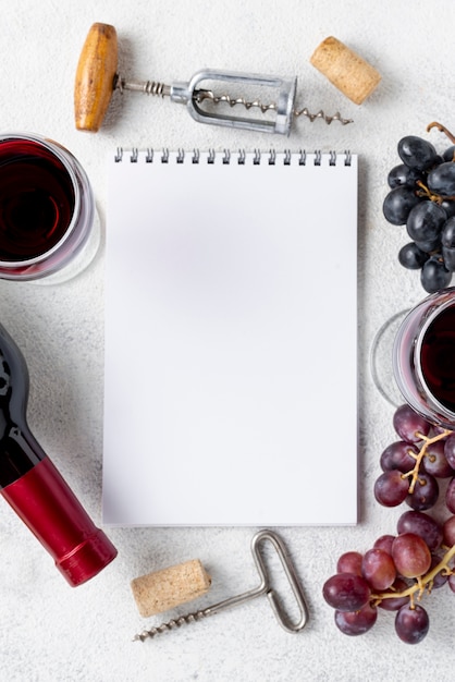 Top view notebook with frame of grapes and wine