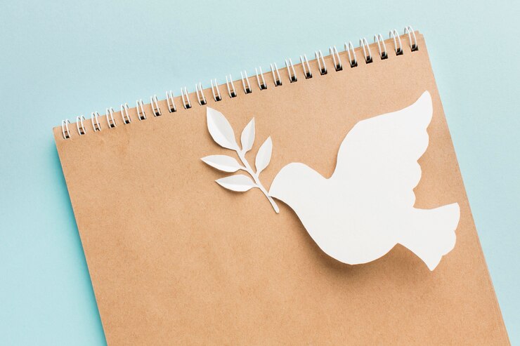Free Photo top view of notebook with paper dove