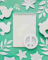 Free photo top view of notebook with peace sign and paper doves