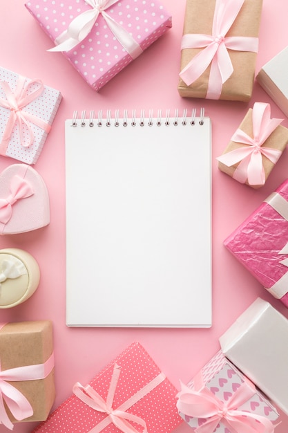 Top view of notebook with pink gifts
