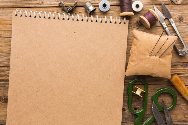 Top view of notebook with scissors and thread