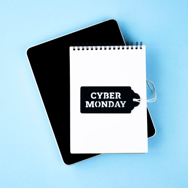Top view of notebook with tablet and tag for cyber monday