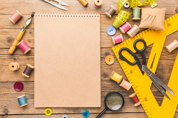 Top view of notebook with thread and scissors