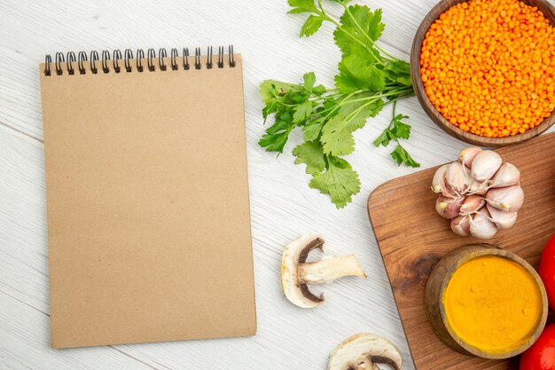 Top view notepad garlic turmeric bowl on chopping board