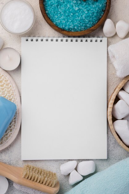 Top view notepad surrounded by spa stones and salt