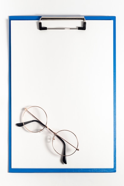 Top view of notepad with glasses on top