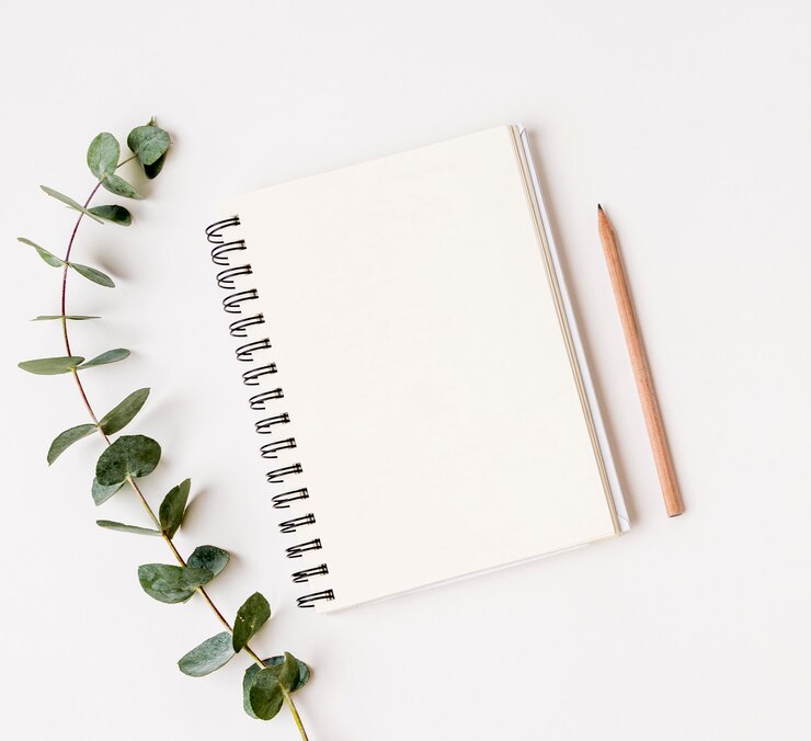 Free Photo top view notepad with green leafs concept