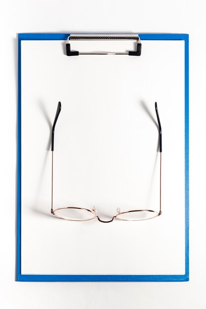 Top view of notepad with pair of glasses on top