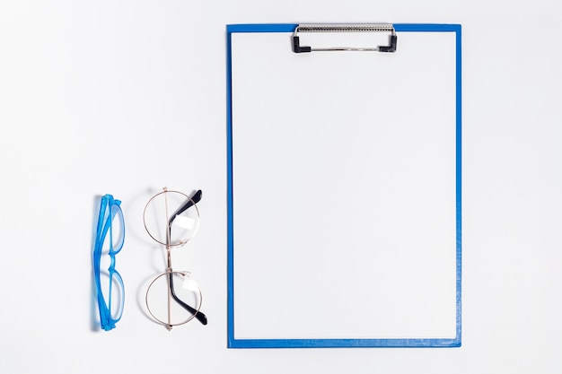 Top view of notepad with pair of glasses