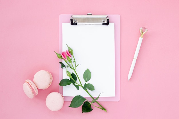 Top view of notepad with rose and macarons