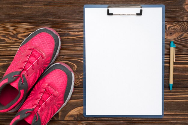 Top view of notepad with sneaker and pen