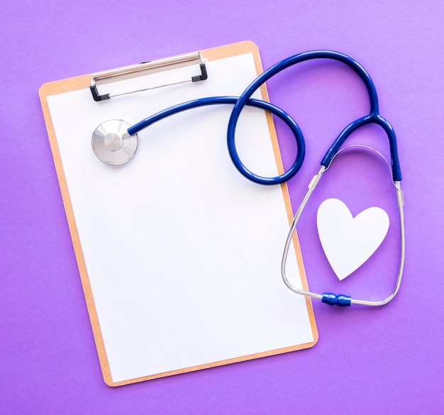 Top view of notepad with stethoscope and paper heart