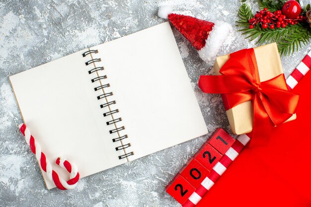 상위 뷰 메모장 크리스마스 사탕 나무 블록 회색 흰색 테이블에 있는 작은 산타 모자