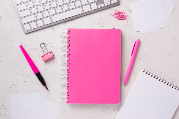 Top view of notepads on desk with paper clips and sticky notes