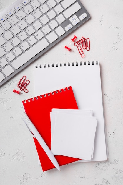 Top view of notepads on desk with pen and keyboard