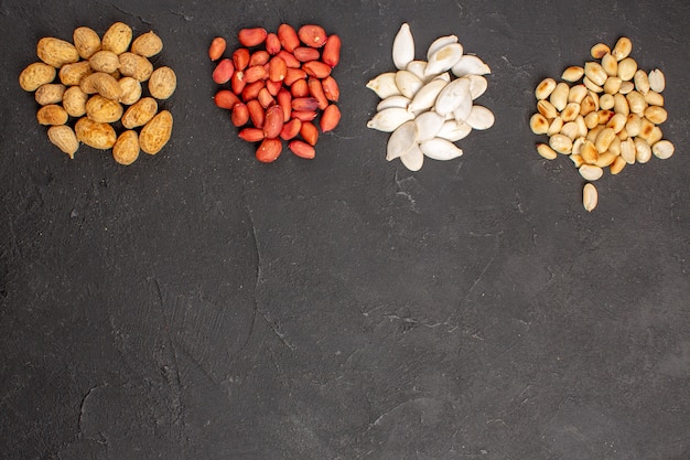 Top view of nut composition with different fresh nuts on dark surface